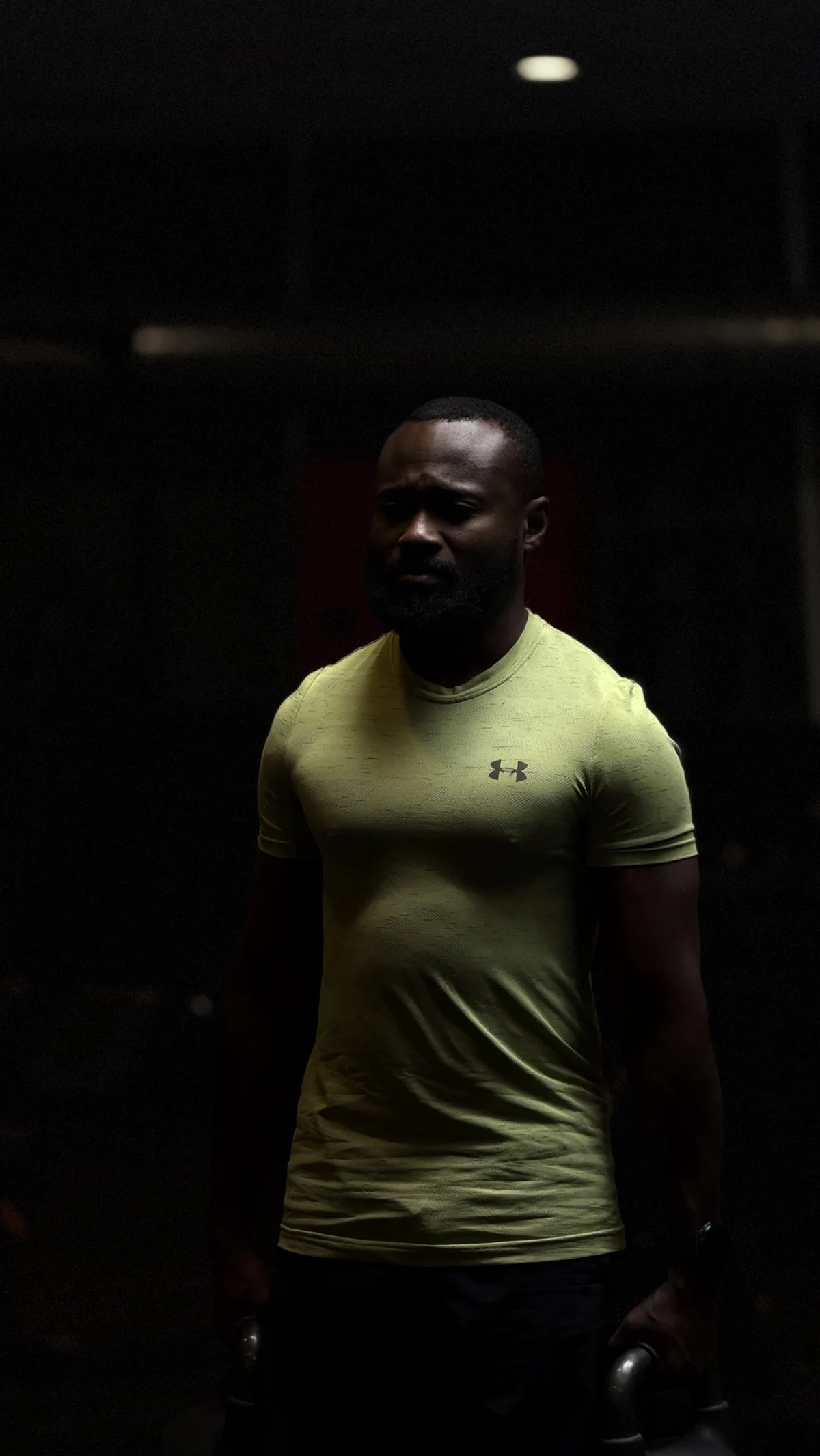 Bouba Ousmana, coach Focus & Performance, en salle avec une kettlebell dans chaque main
